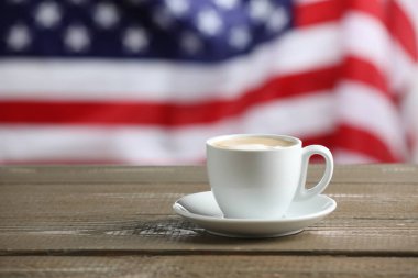 Amerikan bayrağına karşı ahşap masada fincanda Aromatik kahve, metin için yer