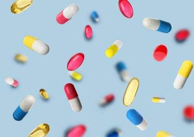 Açık mavi arka planda uçuşan bir sürü farklı hap.