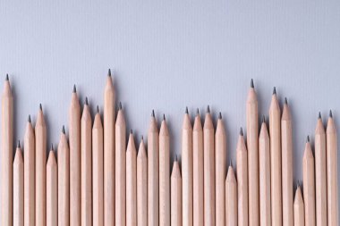 Açık gri arka planda bir sürü kalem, üst manzara. Metin için boşluk