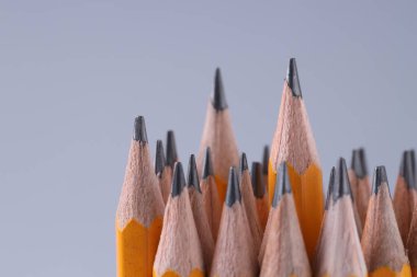 Açık gri arka planda bir sürü kalem, yakın plan. Metin için boşluk