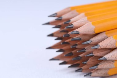 Açık gri arka planda bir sürü kalem, yakın plan. Metin için boşluk