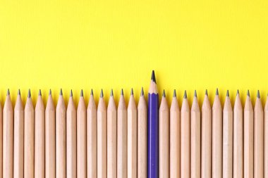 Sarı arka planda grafit olanlar arasında bir mavi kalem, en üstte. Metin için boşluk