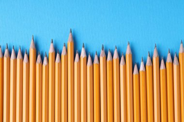 Açık mavi arkaplanda birçok kalem, üst görünüm