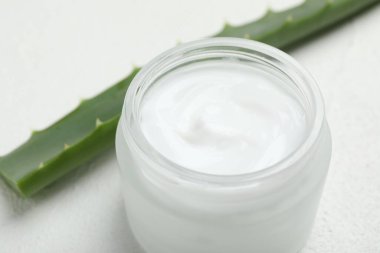 Beyaz desenli arka planda krem ve aloe yaprakları, yakın plan