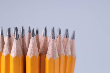 Açık gri arka planda bir sürü kalem, yakın plan. Metin için boşluk