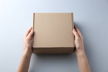 Beyaz arka planda boş karton kutusu olan kadın, yakın plan. Tasarım için model