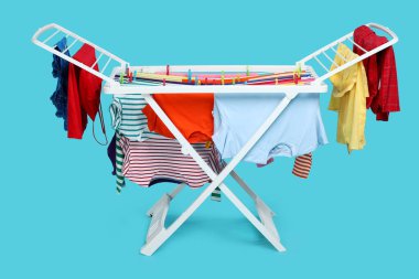 Açık mavi arka planda temiz çamaşırlı kuru askı.