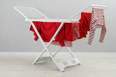 Gri duvarın yanında temiz çamaşırları olan kuru askı.