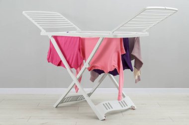 Gri duvarın yanında temiz çamaşırları olan kuru askı.