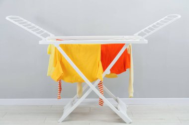 Gri duvarın yanında temiz çamaşırları olan kuru askı.