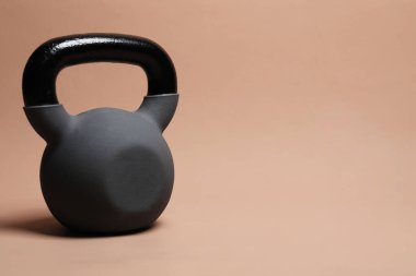 Bej arka planda ağır bir kettlebell. Metin için boşluk