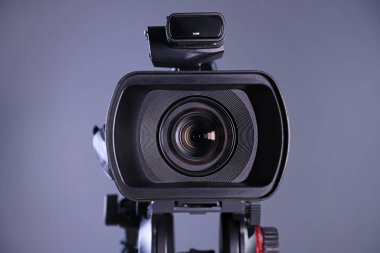 Gri arkaplanda modern video kamera, yakın plan