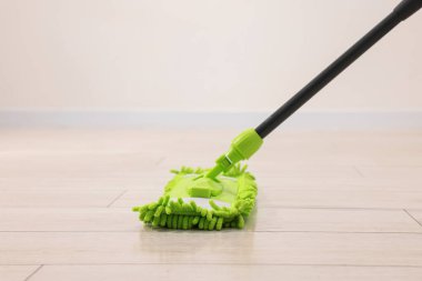 İçerideki ahşap zeminde mikrofiber paspas. Temizlik ekipmanı