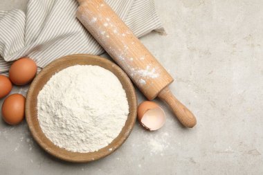 Yuvarlanan iğne, un ve yumurta açık gri arka planda, düz yerde. Metin için boşluk