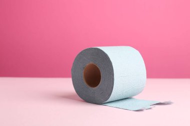 Pembe arka planda mavi tuvalet kağıdı rulosu. Metin için boşluk
