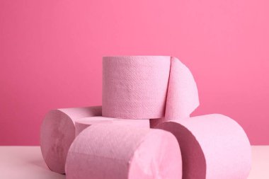 Pembe arka planda renkli tuvalet kağıdı ruloları