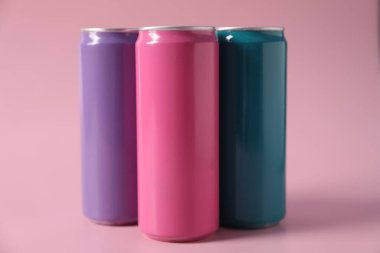 Pembe arka planda renkli alüminyum içecek kutuları