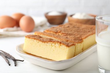 Lezzetli Japon Castella sünger keki ve malzemeler beyaz masada, yakın plan.