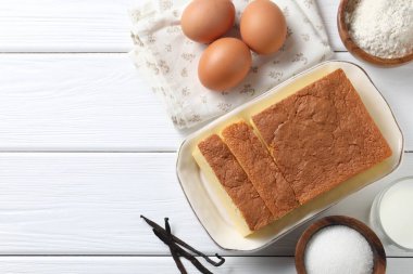 Lezzetli Japon Castella sünger keki ve beyaz ahşap masa üzerindeki malzemeler, düz yatak. Metin için boşluk