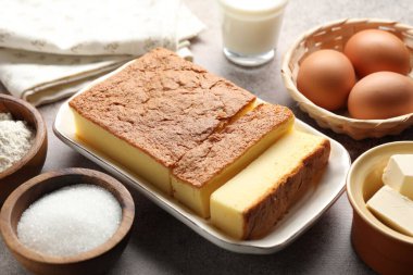 Lezzetli Japon Castella sünger kek ve malzemeler ışık masasında, yakın plan.