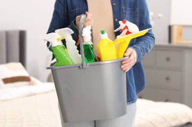 Elinde bir kova temizlik malzemesi olan kadın, yakın çekim.