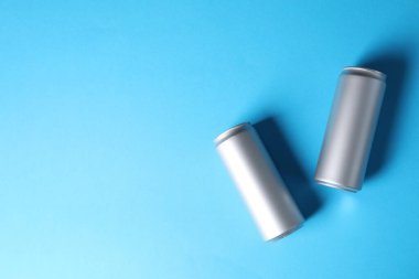 Açık mavi arka planda iki teneke kutu, üst manzara. Metin için boşluk
