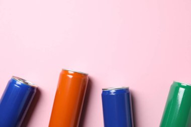 Açık pembe arka planda bir sürü teneke kutu var. Metin için boşluk