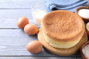 Lezzetli Japon Castella sünger keki ve gri ahşap masadaki malzemeler, yakın plan. Metin için boşluk