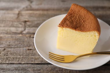 Lezzetli Japon Castella süngerli kek ve çatal, ahşap masa, yakın plan. Metin için boşluk