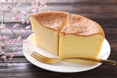 Lezzetli Japon Castella sünger keki, çingene çiçeği ve ahşap masa çatalı, yakın plan.