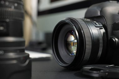 Profesyonel kamera ve lens siyah masada, seçici odak