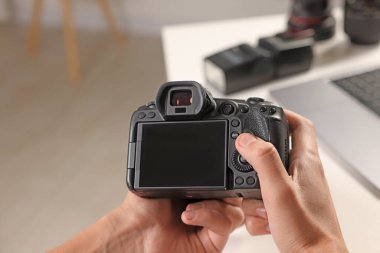 Beyaz masadaki profesyonel kameralı fotoğrafçı, yakın plan.