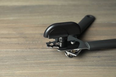 Ahşap masada bir konserve açacağı, yakın plan. Metin için boşluk