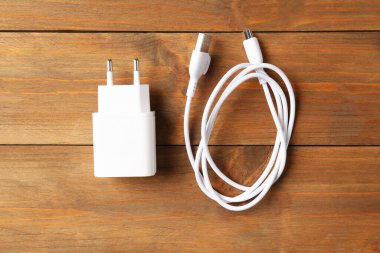 USB güç adaptörü, ahşap masa üzerinde şarj kablosu, üst görünüm