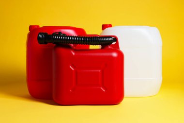 Three colorful plastic canisters on yellow background