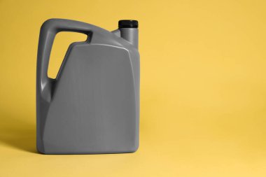 One grey plastic canister on yellow background, space for text