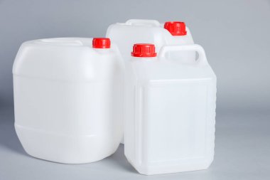 Many white plastic canisters on light grey background