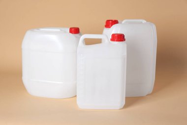 Many white plastic canisters on beige background