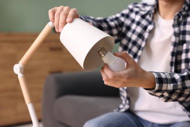 Evdeki ampulü değiştiren adam, yakın plan.