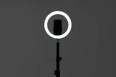 Gri arkaplanda akıllı telefonu olan halka lambası