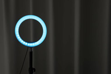 Siyah perdenin yanında parlayan bir lamba. Metin için boşluk