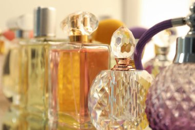 Ayna yüzeyindeki şişelerde farklı aromatik parfümler, yakın plan.