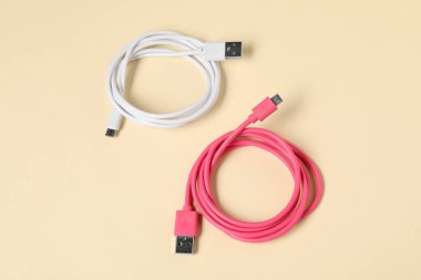 USB charge cables on beige background, above view