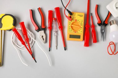 Different electrical tools on grey background, flat lay