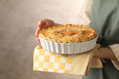 Gri arka planda ev yapımı turtası olan kadın, yakın plan. Metin için boşluk