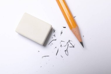 Eraser, pencil and scraps on sheet of paper, flat lay