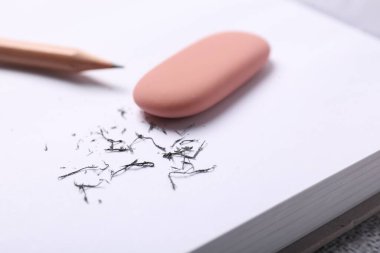 Silgi, kalem, defter ve kırıntılar masada, yakın plan