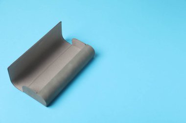 Empty glasses case on light blue background. Space for text