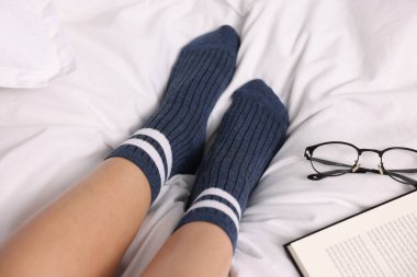 Yatakta mavi çorap giyen kadın, yakın plan.