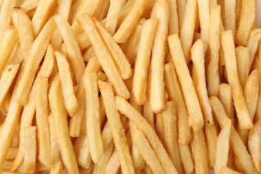 Pile of delicious French fries as background, top view